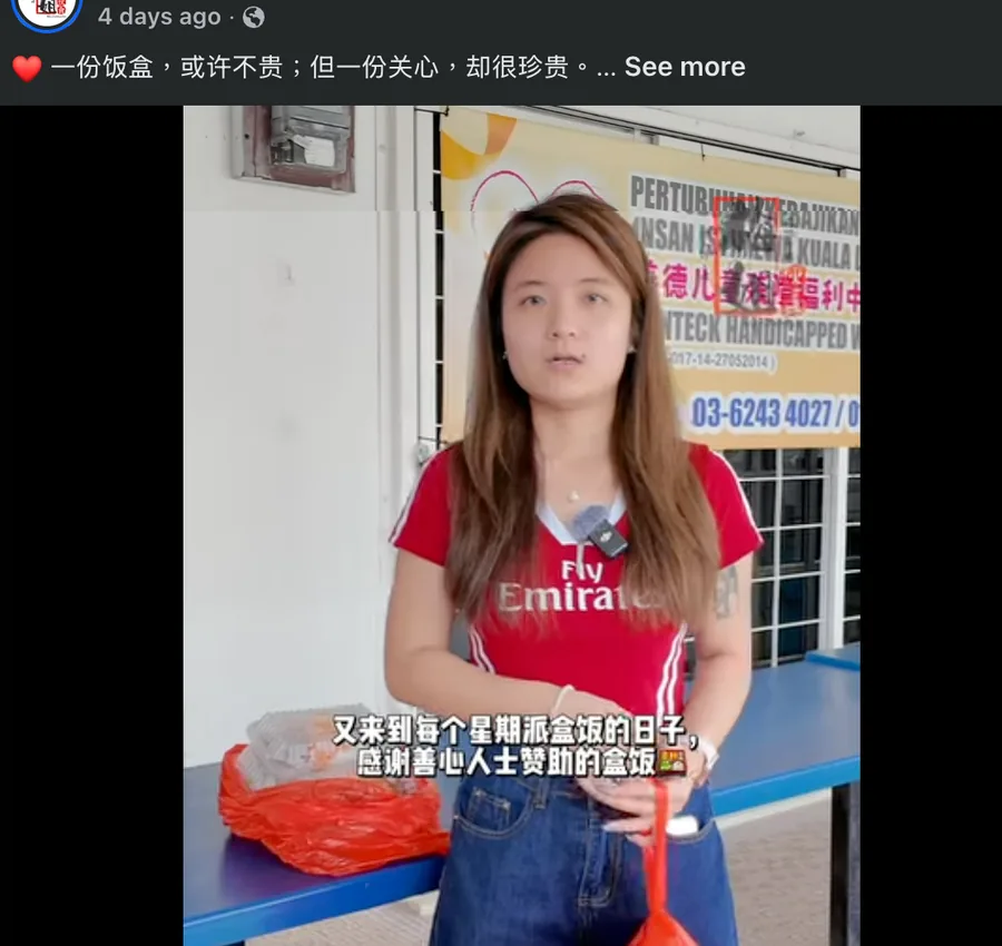 工作人员提着两袋爱心饭盒准备出发派送